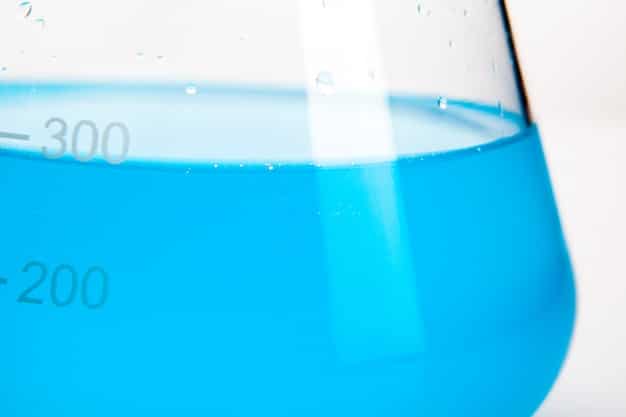 A close-up shot of a water sample being tested in a university lab, with sophisticated testing equipment visible in the background. Focus on the precision and scientific rigor of the testing process.