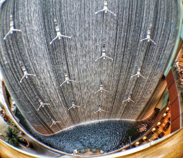 Close-up, detailed shot of a wave energy converter (WEC) mechanism above water, emphasizing its intricate engineering and moving parts. The image captures the interplay of mechanical and electrical components, highlighting the technology's sophistication. Gears, pistons, and wiring are visible, conveying the complexity of converting wave motion into usable energy.
