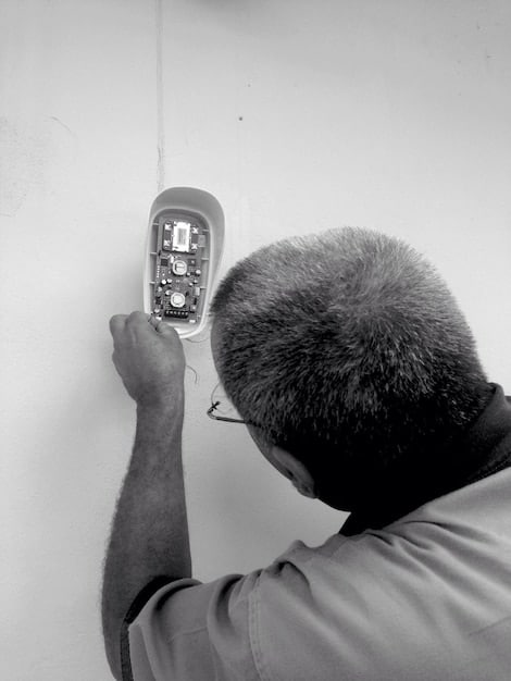 A close-up shot of a technician using a specialized device to measure the electrical output of a thin-film solar panel in an outdoor testing facility. The image should highlight the precision and technology involved in performance analysis.