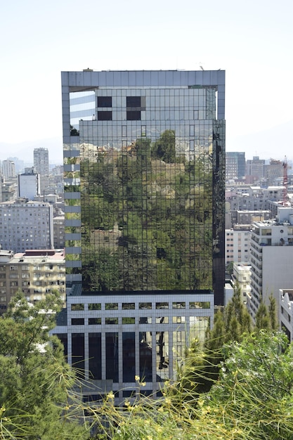A wide shot of an urban landscape with a modern vertical farm building integrated into the cityscape. The image emphasizes the co-existence of urban infrastructure and sustainable agriculture, highlighting the farm's potential to blend into the urban environment.