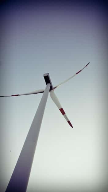 A close-up of a wind turbine blade showcasing advanced aerodynamic features, such as vortex generators and serrated trailing edges. The blade is made of composite materials and has a smooth, curved surface. The image highlights the intricate design elements that contribute to increased efficiency and reduced noise.