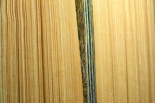 A close-up shot of the edge of a cross-laminated timber panel, displaying the layered wood structure and the adhesive bonding. The wood grain is clearly visible, highlighting the natural texture and patterns of the timber. The image conveys the raw, organic nature of the material and its engineered construction.