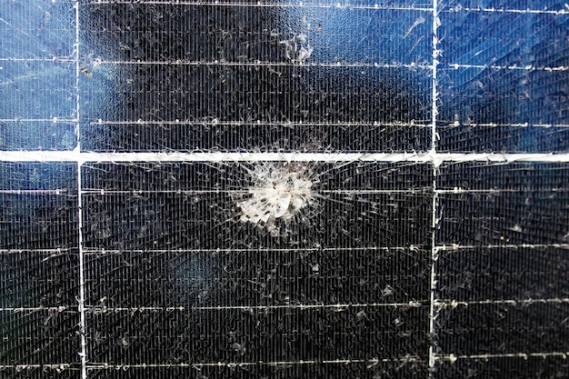 A close-up shot of a thin-film solar panel with visible cracks and discoloration, indicating weathering and degradation due to harsh environmental conditions. The image highlights the impact of UV radiation and temperature fluctuations on the panel's surface.