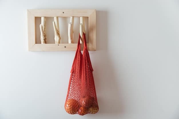 A collection of reusable grocery bags and produce bags hanging on hooks in a kitchen. Some bags are made of cotton, while others are mesh. The bags are colorful and visually appealing, promoting a sustainable lifestyle.