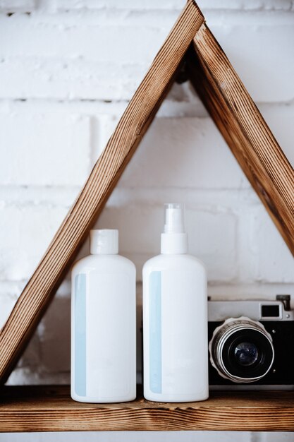 A bathroom shelf displaying homemade personal care products in reusable glass containers, including shampoo, conditioner, and deodorant. Natural ingredients like essential oils and herbs are visible, emphasizing the eco-friendly nature of the products.