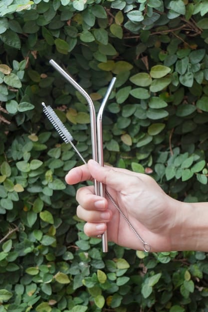 Close-up of a hand refusing a plastic straw from a waiter, with a focus on the reusable stainless steel straw in the background.