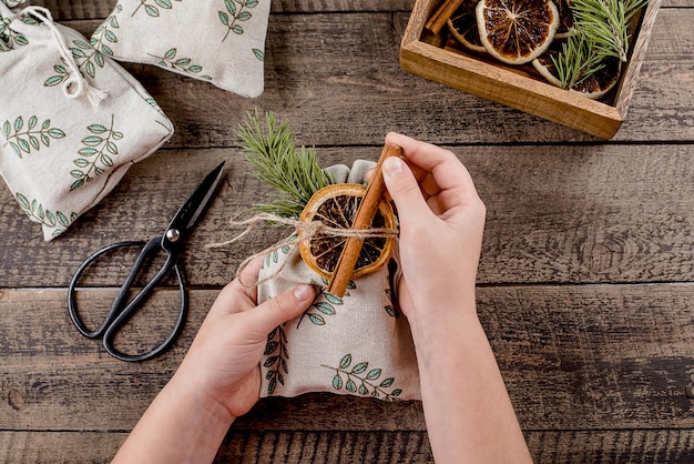 A person wrapping a gift with reusable fabric wrap, showcasing a sustainable and eco-friendly alternative to traditional wrapping paper.